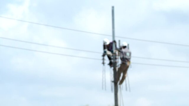Blurred  Electricians are working on the post, out door  Chiangmai Thailand.