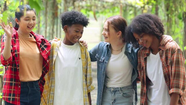 Happy Multi-Cultural Children teenage. Group portrait diverse teenage boy and girls. Kids walking talking leaning outdoor summer camp