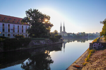 Odra river and tree on Ostrow Tumski in the morning fog. Sunrise over river. Wroclaw.