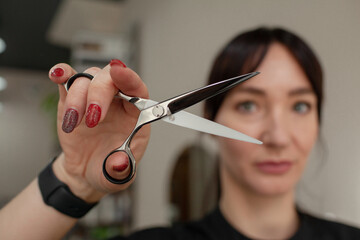 
Close-up of female hands holding the hair rows in professional hairstyles salon. The hairdresser...