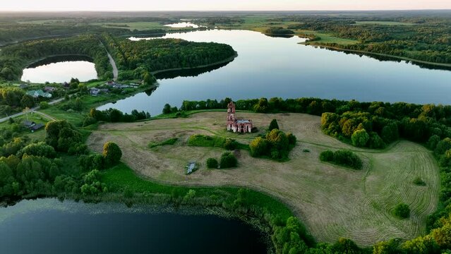 Lake in rural, aerial view. Freshwater Lakes. Abandoned Trinity Church in village of Belaya Tserkov. Lake Chereiskoye in Chereya village. Lighthouse on island. Panoramic landscape view of river.