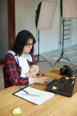 Creative female photographer with cute cat, using graphic drawing tablet and stylus pen