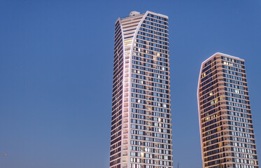 Fototapeta premium Skyscrapers landscape at night. Real estate concept. Two tall buildings with copy space background.
