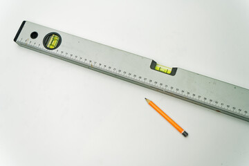 spirit level and orange pencil n white isolated background