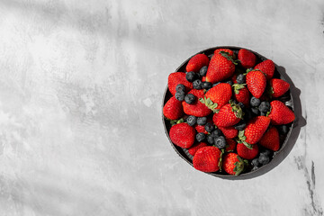 strawberries and blueberries on grey background