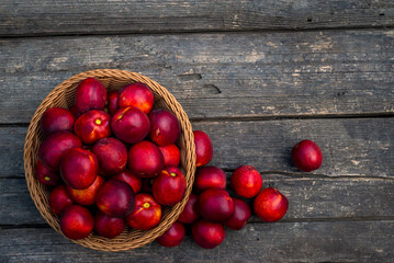 Tray of Fresh red nectarines. Wooden background. Top view Fresh organic ripe  wood table background woven basket fruit