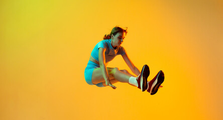 Professional longjumper. One female athlete in sports uniform jumping isolated on yellow...