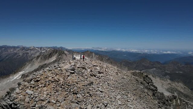 Drone footage of a man standing on the Aneto summit in the Pyrenees mountains.