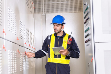 Maintenance engineer inspect relay protection system with laptop tablet computer. Electrician...