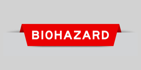 Red color inserted label with word biohazard on gray background