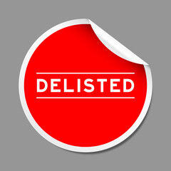 Red color peel sticker label with word delisted on gray background