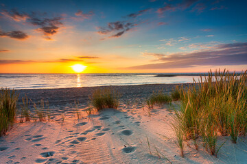 Beautiful sunset on the beach of the Sobieszewo Island at the Baltic Sea. Poland - obrazy, fototapety, plakaty