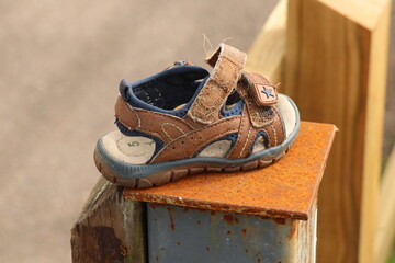 Lost child's sandal has been put on a post by the pavement, so that the owner might find it again