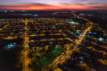 Fototapeta na wymiar Vista aérea da cidade de Paulínia durante a noite. Pôr do sol no interior de São Paulo. Céu vermelho.