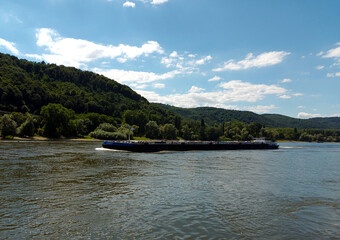 Frachtschiff auf dem Rhein bei Andernach in Rheinland-Pfalz vor blauem Himmel.