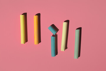 colored crayons pastels of delicate shades on a pink background