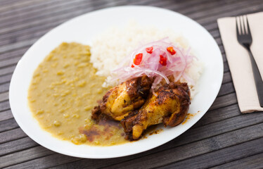 chicken wings with mashed peas, rice and pickled onions on white plate