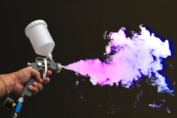 Hand holding paint spray gun Paint spray on floors Image of the painter's arm hand holding industrial size spray gun used for industrial painting and coating and isolated on background clipingpart