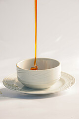 In natura honey, being poured into a white pot, just produced © BY BRAZIL