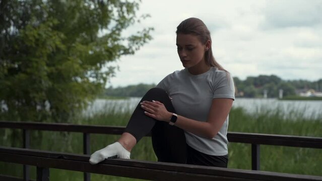 girl goes in for sports, does stretching in the park on the bridge