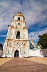 Obraz premium Classic wide-angle view of belfry of Saint Sophia Cathedral. UNESCO World Heritage Site. Tree leaves border. Natural frame. Chestnut tree in the foreground. Beautiful sunny day