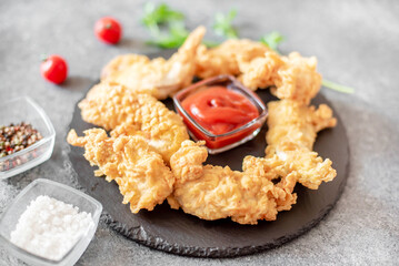 Chicken strips on stone background