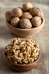 Peeled walnuts and whole walnuts on burlap sack