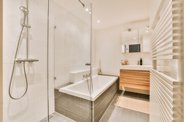 Sinks with mirrors and clean bathtub located near shower box with glass door in modern bathroom...