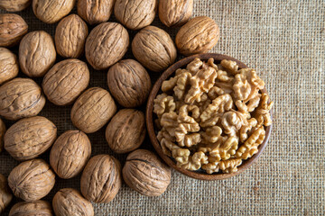 Peeled walnuts and whole walnuts on burlap sack