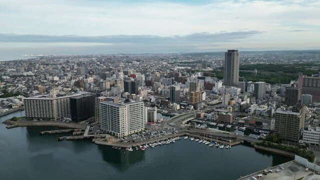 Aerial pullback on downtown Akashi and boats docked in harbor