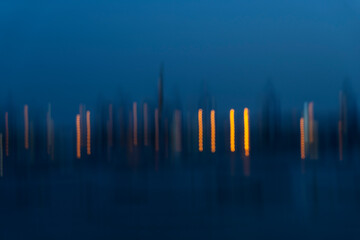 Motion Blurr of industry background with defocused cargo dock terminal in sea with colorful bokeh lights at midnight. Urban and industry backdrop
