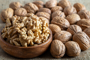 Peeled walnuts and whole walnuts on burlap sack
