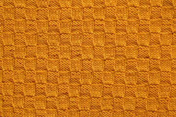 Yellow soft knited texture. Knitted chess pattern. Knited background.