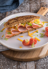 Healthy breakfast sandwich with an oatmeal pan bread. Topped with thin sliced turkey breast, cheddar cheese and chives