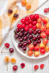 Colorful assorted mix of red and yellow cherries on a white background. Sweet vegan food. Natural dessert. Top view.