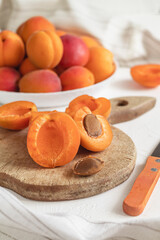 Apricot slices close up on a wooden cutting board. Fresh sweet organic apricots. Apricots peeling process.
