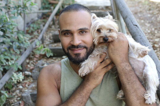 Ethnic man and his cute little Yorkshire terrier 