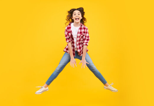 Amazed Teenager. Excited Teen Girl. Full Length Overjoyed Teenager Kid Girl 12 13 14 Year In Casual Wear Jumping Old Isolated On Yellow Background Studio. Funny Jump. Child In Summer Movement Dress.