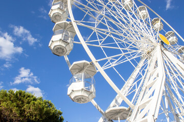 Beautiful White Ferris wheel close-up against a clear blue sky in Italy, Calabria. Ferris wheel on...