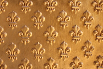Fleur de Lis pattern painted gold over wooden texture for background. Repeated fleur-de-lis pattern. - obrazy, fototapety, plakaty