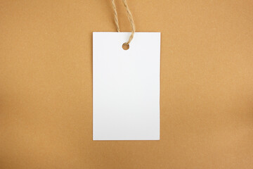 White price tag on a brown background. Mockup. Place for text.