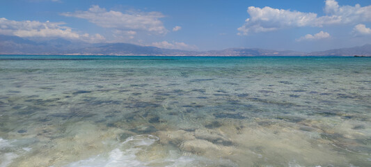 beautiful landscape with blue sea, waves, sand, and water on a sunny day.