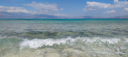 beautiful landscape with blue sea, waves, sand, and water on a sunny day.