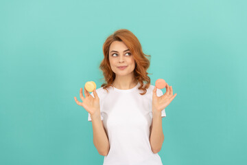 smiling girl hold sweet macaron french cookie on blue background