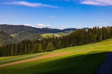 Fototapeta na wymiar schweizer landschaft mit hügel felder wiesen und wälder