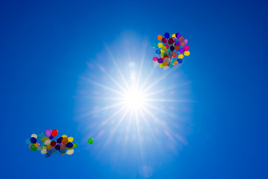 farbige partyballone an hochzeit steigen zum blauem himmel