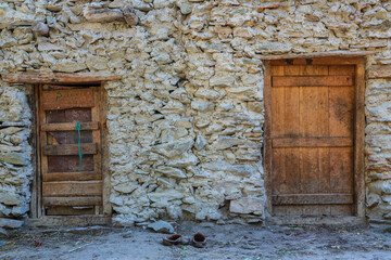 Wooden door and stone wall. Traditional house exterior of the village in Hunza valley, Gilgit-Baltistan, Pakistan