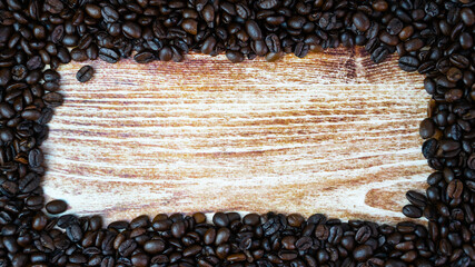 Frame of coffee beans on a wooden background. Coffee day. Place for yur text. Top view. Selective focus.