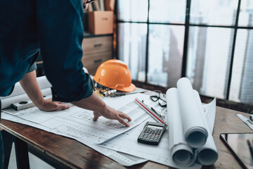 Engineering working with drawings inspection on the office desk and Calculator, triangle ruler,...