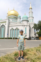 Tourist boy, cute child, fashion kid and Moscow Cathedral Mosque in Moscow city, Russia. Child and Moscow landmark, monument, sight, view. Islamic, muslim architecture 